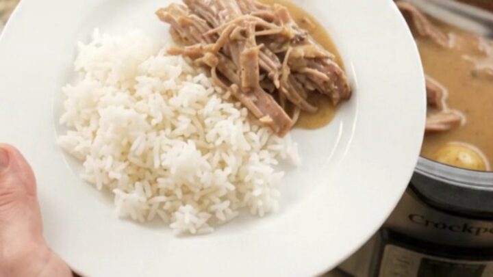 Slow-cooker pork shoulder with Dijon cream gravy, potatoes, and carrots in a black crockpot