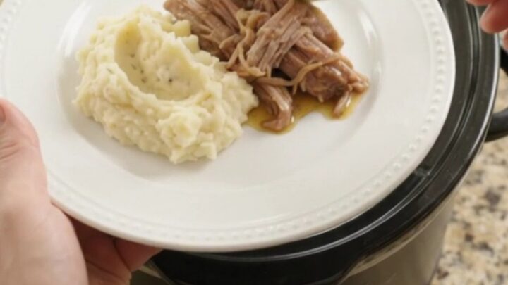 Pulled pork shoulder with portobello mushrooms in a slow cooker, topped with butter