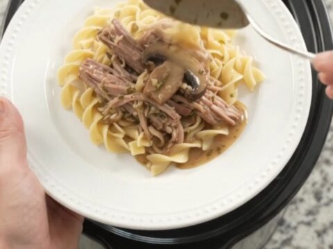 Slow-cooker pork shoulder with portobello mushrooms and herb butter gravy in a black crockpot