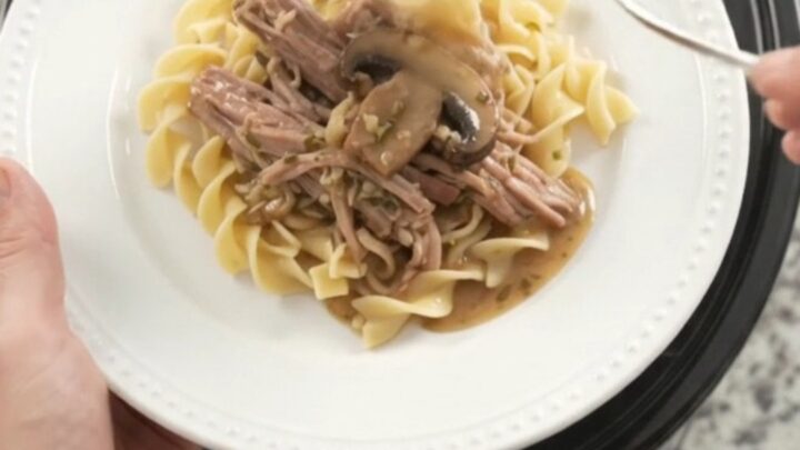 Slow-cooker pork shoulder with portobello mushrooms and herb butter gravy in a black crockpot