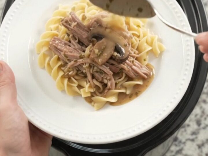 Slow-cooker pork shoulder with portobello mushrooms and herb butter gravy in a black crockpot