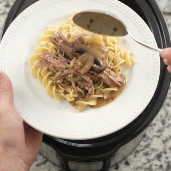 Slow-cooker pork shoulder with portobello mushrooms and herb butter gravy in a black crockpot