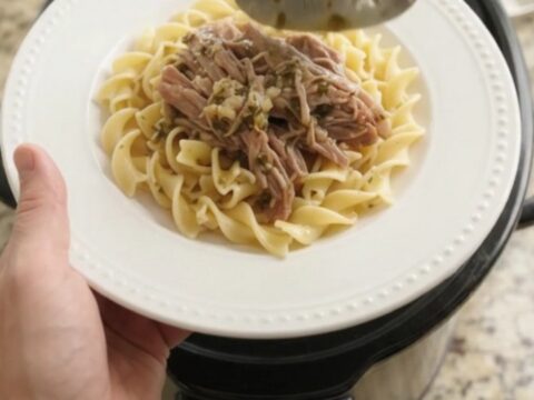 Shredded pork sirloin roast with pepperoncini and garlic butter gravy in a slow cooker