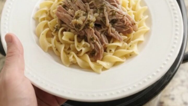 Shredded pork sirloin roast with pepperoncini and garlic butter gravy in a slow cooker
