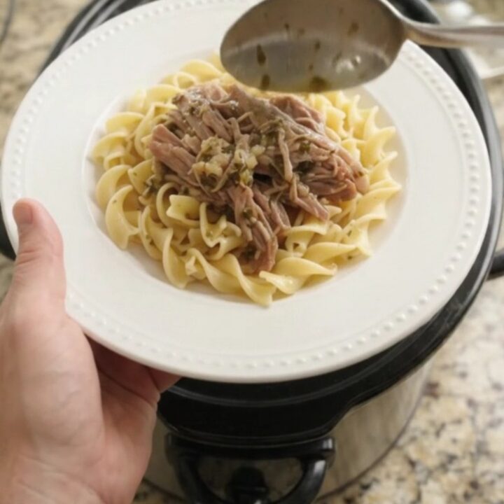 Shredded pork sirloin roast with pepperoncini and garlic butter gravy in a slow cooker