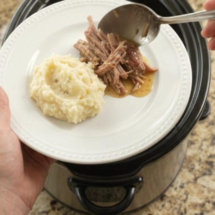 Shredded pork sirloin roast in a slow cooker with pepperoncini and buttery jus