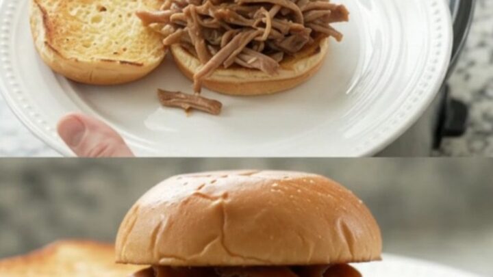 Shredded pork sirloin roast in a glossy brown gravy with whole pepperoncini, in a black slow cooker insert.