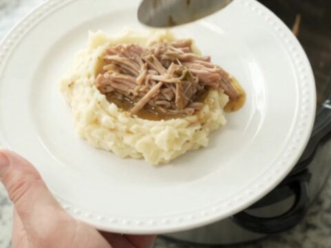 Shredded pork sirloin roast in a slow cooker with golden butter jus