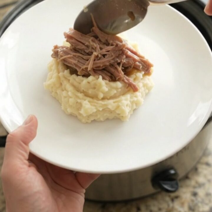 Shredded pork sirloin roast in a slow cooker with garlic and herbs