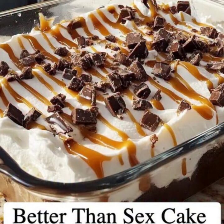 A glass casserole dish filled with Better Than Sex Cake showing distinct layers of chocolate, caramel, and cream.