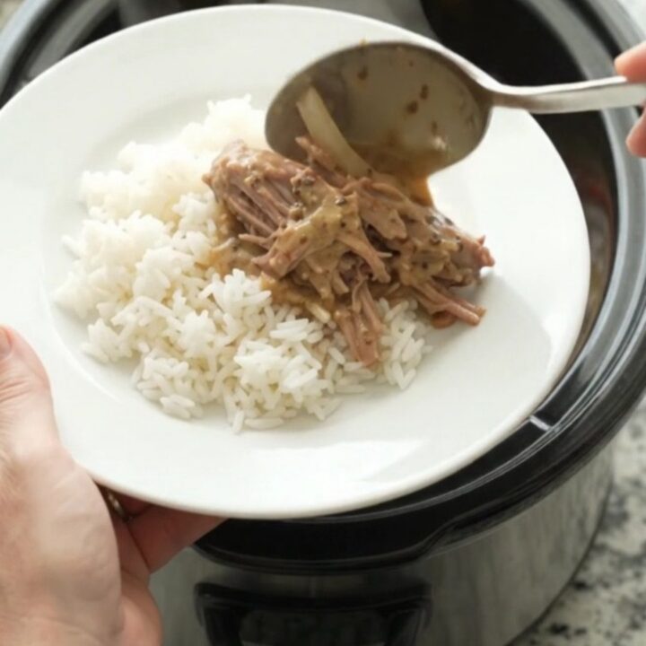 Shredded pork sirloin roast with bell peppers and onions in a creamy Dijon sauce, served in a slow cooker