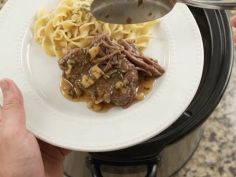 Fork-tender pepperoncini ranch garlic butter pot roast in a slow cooker with rich gravy