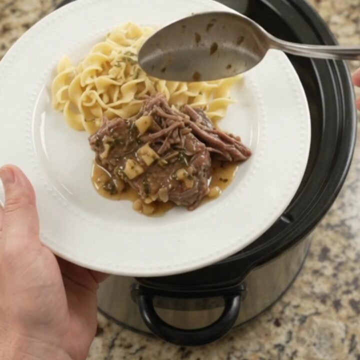 Fork-tender pepperoncini ranch garlic butter pot roast in a slow cooker with rich gravy