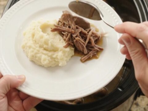 Fork-tender beef bottom round roast with mushrooms and butter jus in a slow cooker