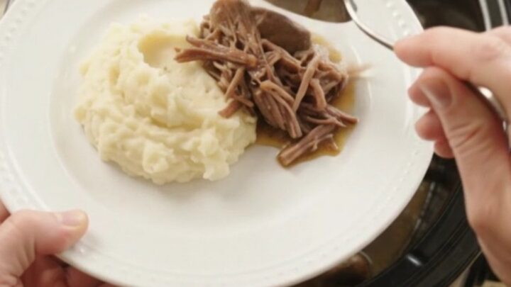 Fork-tender beef bottom round roast with mushrooms and butter jus in a slow cooker