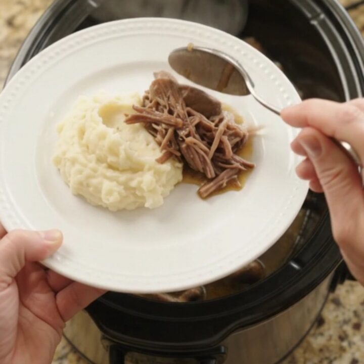 Fork-tender beef bottom round roast with mushrooms and butter jus in a slow cooker