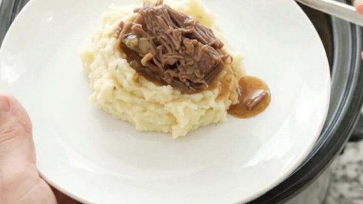 Fork-tender bottom round roast in rich gravy in a slow cooker