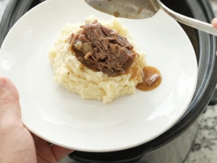 Fork-tender bottom round roast in rich gravy in a slow cooker