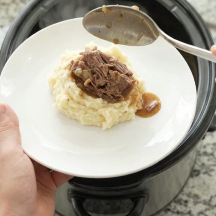 Fork-tender bottom round roast in rich gravy in a slow cooker