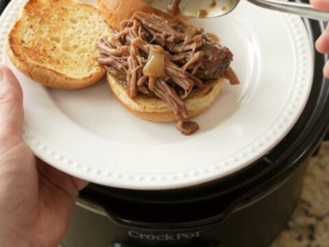 Slow-cooker pot roast with mushrooms and gravy in a black crockpot