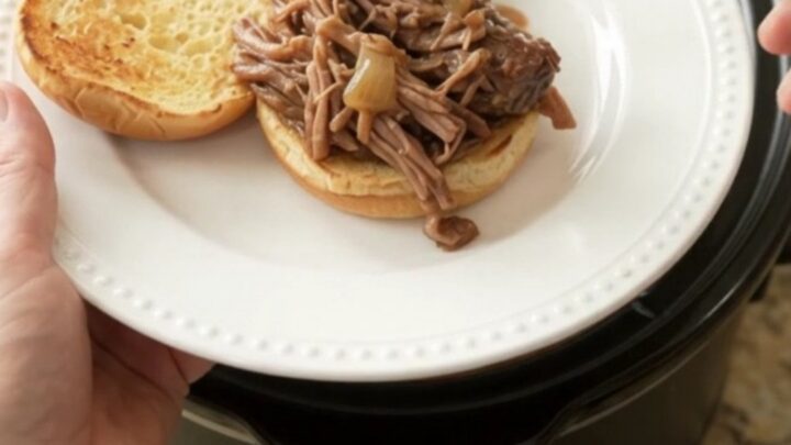 Slow-cooker pot roast with mushrooms and gravy in a black crockpot
