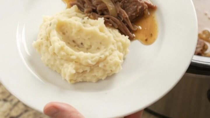 A fork-tender beef roast with caramelized onions and butter sauce in a slow cooker