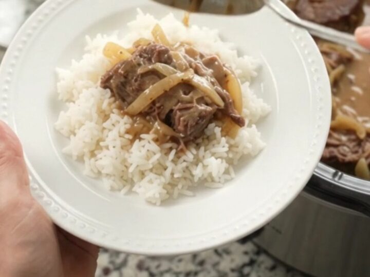 Slow-cooker French onion Dijon cream roast with tender beef and creamy gravy in a black crock