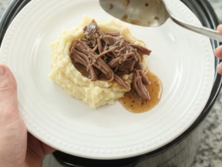 Slow cooker beef roast with potatoes and carrots in golden butter jus