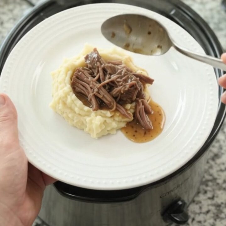 Slow cooker beef roast with potatoes and carrots in golden butter jus