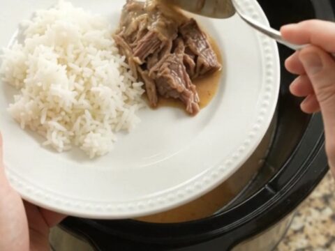 Shredded beef pot roast with potatoes and carrots in creamy Dijon gravy in a slow cooker