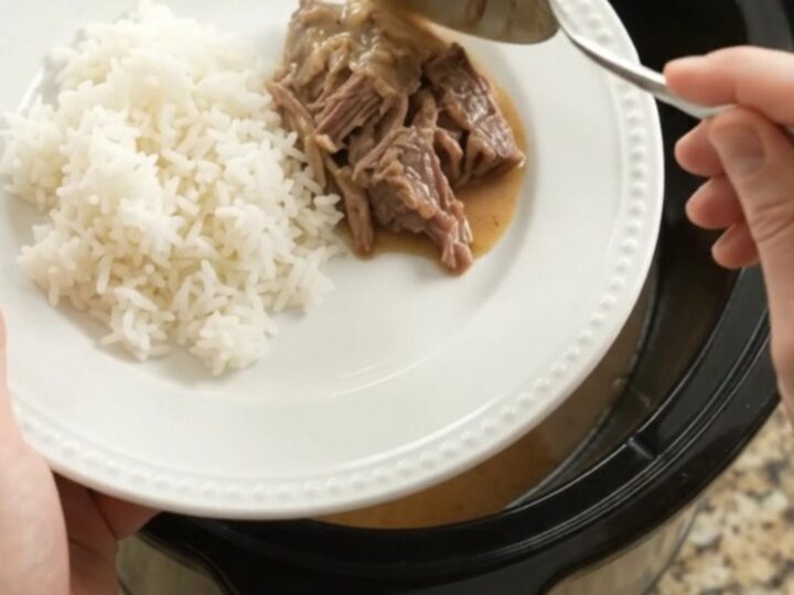 Shredded beef pot roast with potatoes and carrots in creamy Dijon gravy in a slow cooker