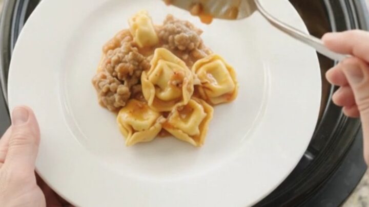 Bubbling Crockpot tortellini with sausage and melted provolone