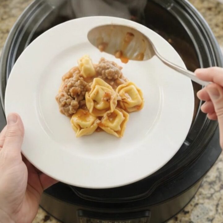 Bubbling Crockpot tortellini with sausage and melted provolone