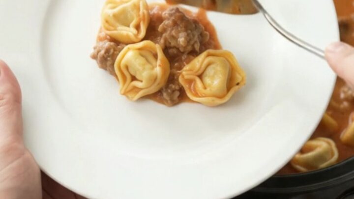 Bubbling Crockpot of Boursin Sausage Marinara Tortellini with melted cheese and steam
