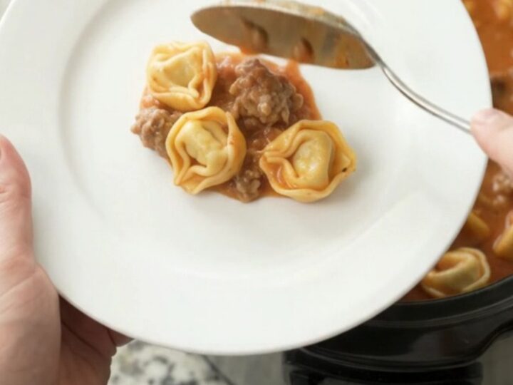 Bubbling Crockpot of Boursin Sausage Marinara Tortellini with melted cheese and steam