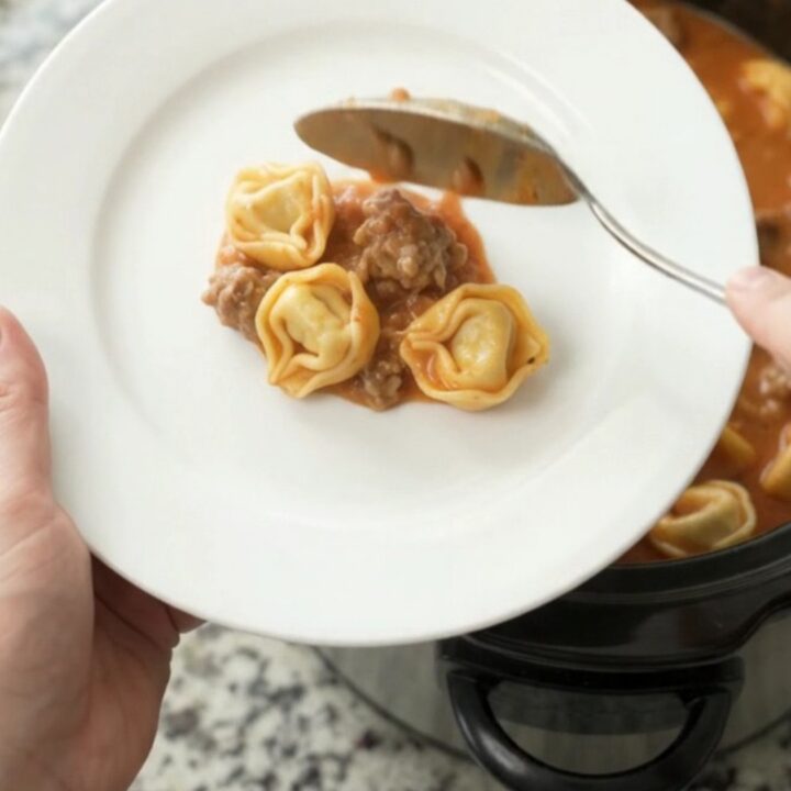 Bubbling Crockpot of Boursin Sausage Marinara Tortellini with melted cheese and steam