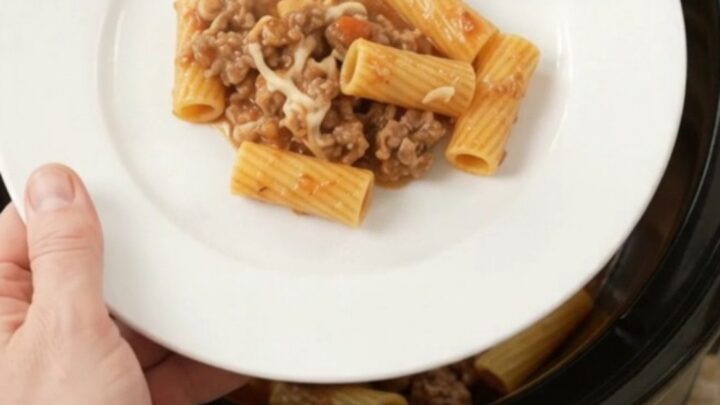 Slow cooker rigatoni with sausage and melted cheese, bubbling in the crockpot