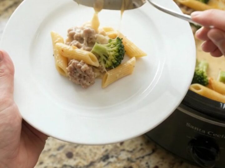 Bubbling slow cooker Parmesan sausage Alfredo penne with melted cheese and steam rising