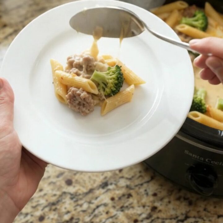 Bubbling slow cooker Parmesan sausage Alfredo penne with melted cheese and steam rising