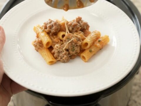 Crockpot filled with creamy baked ziti with sausage and melted mozzarella