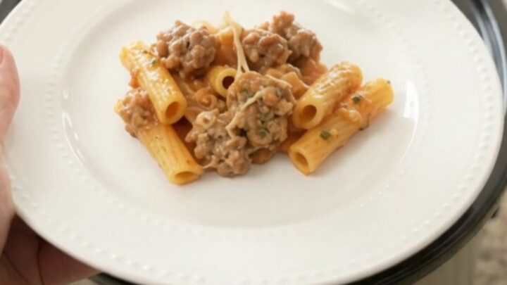 Crockpot filled with creamy baked ziti with sausage and melted mozzarella