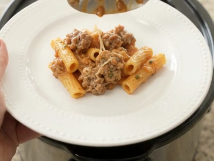 Crockpot filled with creamy baked ziti with sausage and melted mozzarella