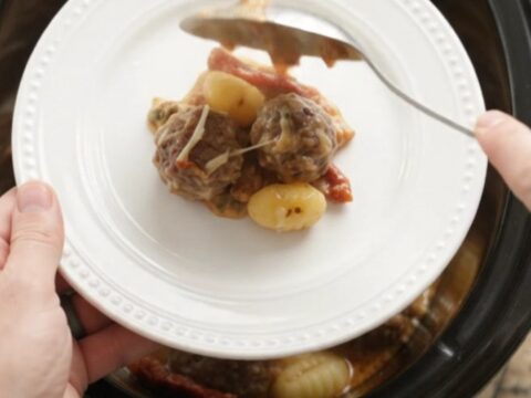 Bubbling Crockpot Parmesan Meatball Tuscan Gnocchi with melted cheese and steam