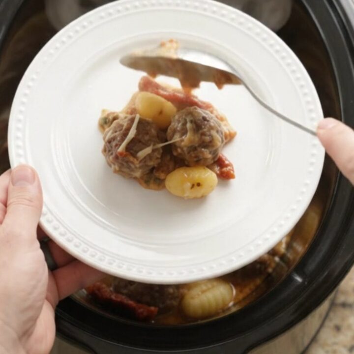 Bubbling Crockpot Parmesan Meatball Tuscan Gnocchi with melted cheese and steam