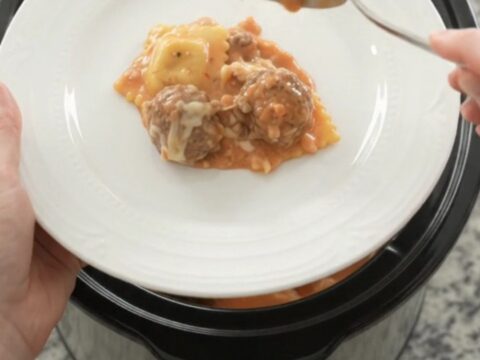 Bubbling Crockpot with meatballs and ravioli in creamy pink vodka sauce topped with melted mozzarella