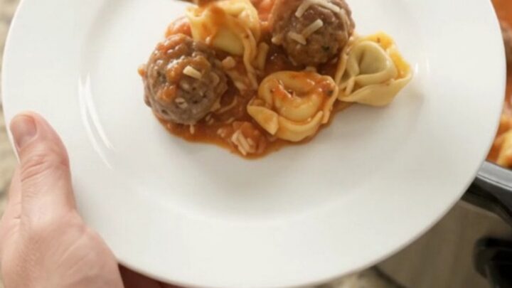 Bubbling Crockpot of Parmesan Meatball Marinara Tortellini with golden cheese crust