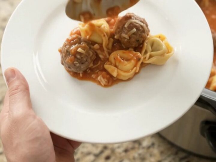 Bubbling Crockpot of Parmesan Meatball Marinara Tortellini with golden cheese crust