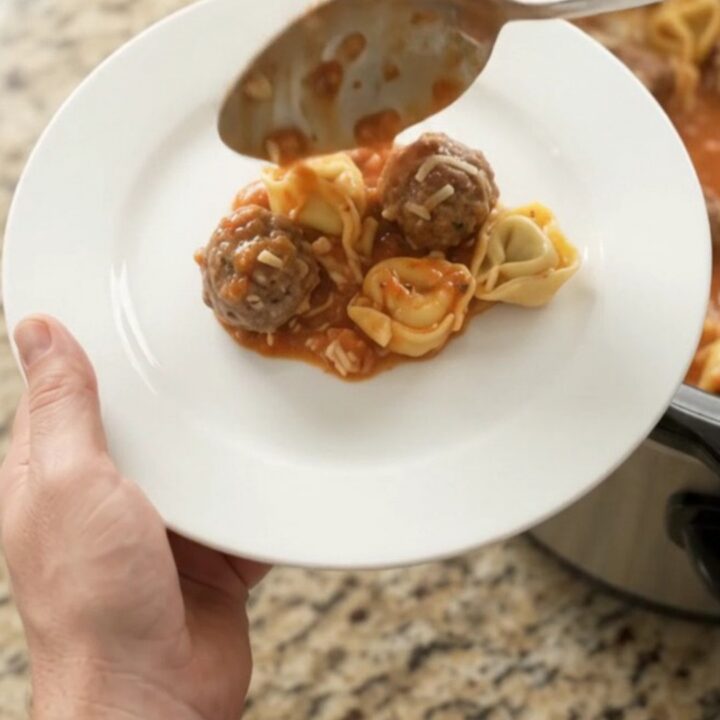 Bubbling Crockpot of Parmesan Meatball Marinara Tortellini with golden cheese crust