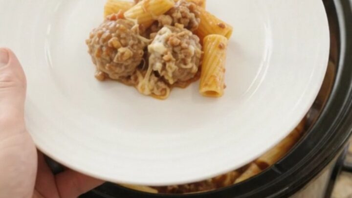 Crockpot Provolone Meatball Bolognese Rigatoni bubbling in the slow cooker with melted cheese and meatballs.