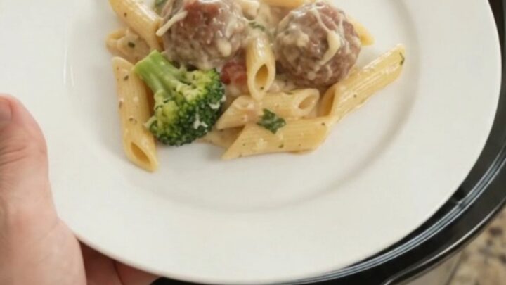 Slow cooker full of creamy mozzarella meatball Alfredo penne with broccoli